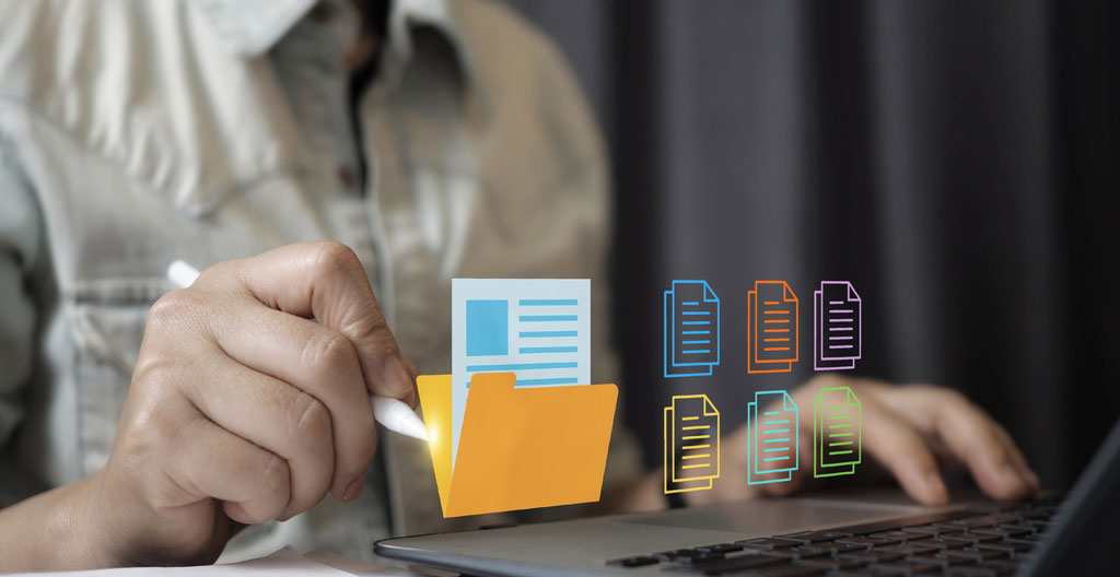 Ordinateur portable affichant le portail gouvernemental français primealaconversion.gouv.fr entouré de documents administratifs organisés incluant carte grise, avis d'imposition et facture LOA sur un bureau contemporain