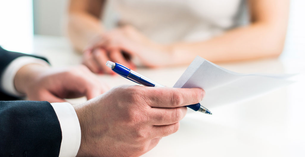 Couple vérifiant leur avis d'imposition français et une brochure de véhicule électrique sur une table contemporaine, avec calculatrice et documents de simulation de financement
